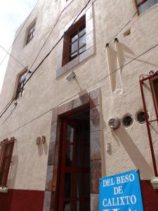 a building with a blue sign in front of it at Hotel El Beso De Calixto in Guanajuato