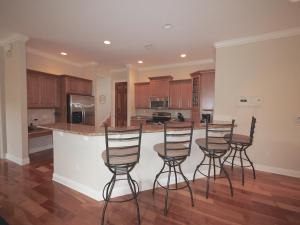 a kitchen with four bar stools and a counter at Naples Beach House in Naples