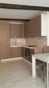 a kitchen with wooden cabinets and a table with chairs at La Merlettaia in Rapallo