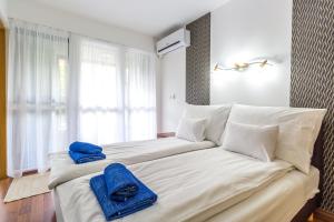 a bedroom with a large bed with blue towels on it at Best Apartments Szeged in Szeged