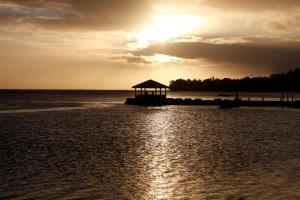 a pier with a gazebo in the water with the sunset at The Warwick Fiji in Korolevu