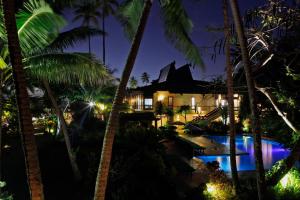 a view of a resort at night with palm trees at The Warwick Fiji in Korolevu
