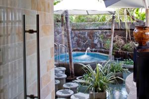a hot tub in a backyard with an umbrella at The Warwick Fiji in Korolevu