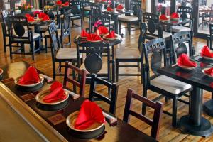 a restaurant with tables and chairs with red napkins on them at The Warwick Fiji in Korolevu