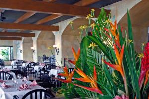 a dining room with tables and flowers in the middle at The Warwick Fiji in Korolevu