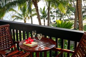 a table with two glasses of wine and a box at The Warwick Fiji in Korolevu