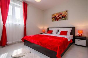 a bedroom with a bed with red sheets and a red blanket at Vila Rozarija in Trogir +36 photos