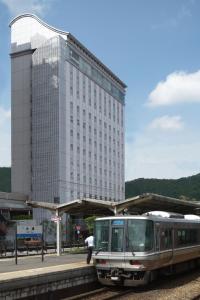 a train on a train track near a building at Hotel Tetora Otsu Kyoto in Otsu
