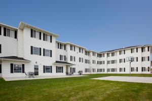 einen Außenblick auf ein großes weißes Gebäude mit Rasen in der Unterkunft GrandStay Residential Suites Rapid City in Rapid City