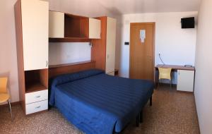 a bedroom with a blue bed and a desk at Hotel Turismo Europa in Casal Borsetti