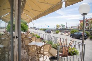 - une rangée de tables et de chaises sur la terrasse dans l'établissement Hotel Turismo Europa, à Casal Borsetti