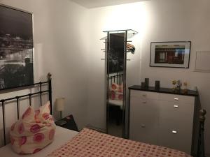 Schlafzimmer mit einem Bett, einer Kommode und einem Spiegel in der Unterkunft Ferienwohnung Happiness in Homburg