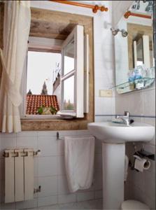 baño con lavabo y aseo y ventana en Hostal Alfonso en Santiago de Compostela