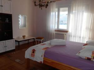 Un dormitorio con una cama grande y una ventana en Apartments Brešan, en Trogir