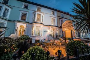 a building with a table and chairs in front of it at The Grafton Guest House in Llandudno