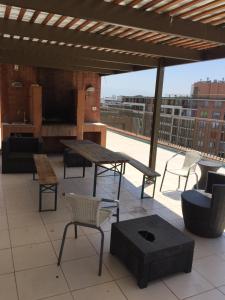 um pátio com uma mesa e cadeiras no telhado em Departamento Vergara em Santiago
