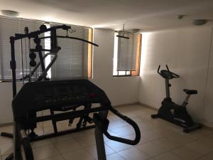 una habitación con gimnasio con cinta de correr y bicicleta estática en Departamento Vergara en Santiago