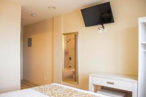 a bedroom with a television on the wall and a bed at Phoenix Hotel Brooklyn Sunset Park in Brooklyn