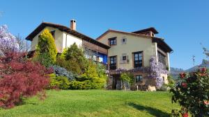 una casa en un patio de césped con flores en Heredad de la Cueste, en Llenín