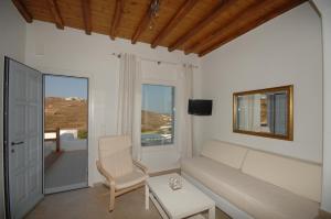 パラダイスビーチにあるLino Apartmentsのリビングルーム(ソファ、テーブル付)、窓が備わります。
