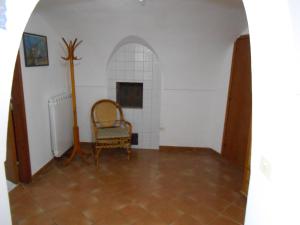 スカウリにあるDammuso Sibaの椅子と暖炉付きの部屋