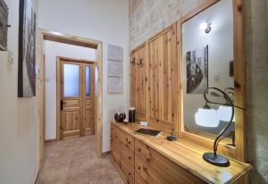 Habitación con escritorio y cómoda de madera con lámpara. en Valletta Apartments 19 en La Valeta