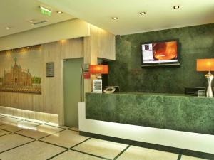 a lobby with a counter and a tv on the wall at TURIM Iberia Hotel in Lisbon