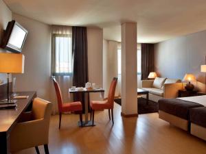 una camera d'albergo con tavolo e soggiorno di TURIM Iberia Hotel a Lisbona