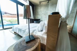 ein Schlafzimmer mit einem Bett und einem Tisch mit einer Lampe in der Unterkunft Sea Two Pool Villa Resort Pattaya in Jomtien Beach