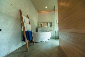 y baño con bañera blanca y lavamanos. en Sea Two Pool Villa Resort Pattaya, en Jomtien Beach