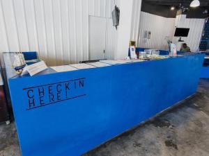 a blue counter with the words check in at Loftel Station Hostel in Bangkok