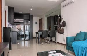 - un salon avec un canapé bleu et une table dans l'établissement Green Bay Condominium by Kevin, à Jakarta