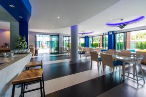 a dining room with tables and chairs and windows at Krabi SeaBass Hotel in Krabi