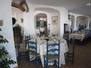 comedor con mesa y sillas azules en Hotel Resort Nuraghe Arvu, en Cala Gonone
