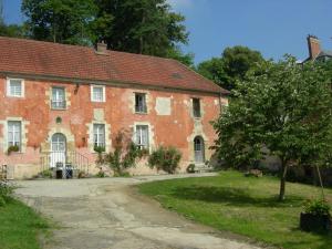 an old brick building with a tree in front of it at La Ferme Rose in Cergy