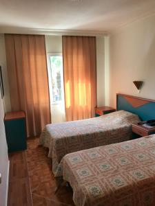 una camera d'albergo con due letti e una finestra di Blue Yacht Marina Apart Hotel a Marmaris