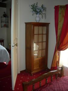 Habitación con armario de madera en un dormitorio. en La Ferme Rose, en Cergy