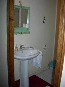 a bathroom with a white sink and a mirror at La Ferme Rose in Cergy