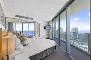 a hotel room with a bed and a large window at Orchid Residences - HR Surfers Paradise in Gold Coast