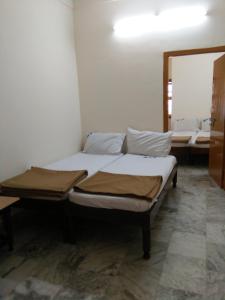 a bed sitting in a room with a mirror at MSR Lodge in Tirupati