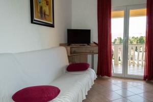 a living room with a white couch and a television at Apartments Zdenka in Starigrad-Paklenica