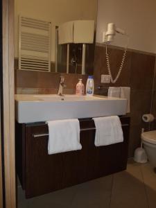 La salle de bains est pourvue d'un lavabo blanc et d'un miroir. dans l'établissement "La Terrazza di Castiglione" APPARTAMENTI VACANZA, à Castiglione della Pescaia