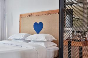 
a bed with a white bedspread and a blue wall at Royal Myconian - Leading Hotels of the World in Elia Beach
