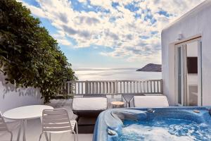 a hot tub on a balcony with a view of the ocean at Royal Myconian - Leading Hotels of the World in Elia Beach