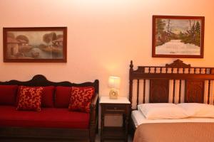 a bedroom with two beds and a red couch at Maria Studios in Neo Klima