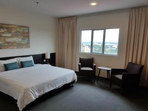 a hotel room with a bed and two chairs at The View Hotel in Segamat