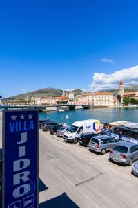 a parking lot with cars parked next to a body of water at Villa Jidro in Trogir