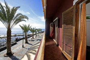 a building with a view of the beach with palm trees at The Gomera Lounge in Valle Gran Rey