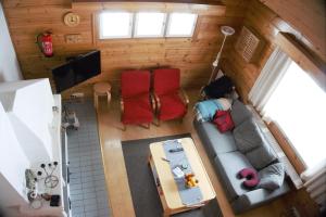 阿卡斯洛姆波羅的住宿－Ylläs Suistotie Cottage，享有客厅的顶部景色,客厅配有沙发和红色椅子