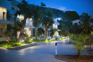 an empty street with trees and buildings at night at Elite 2 Kosta in Dhërmi